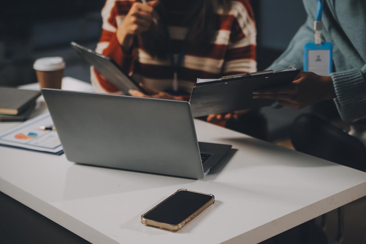 Man working on laptop with mobile phone by his side