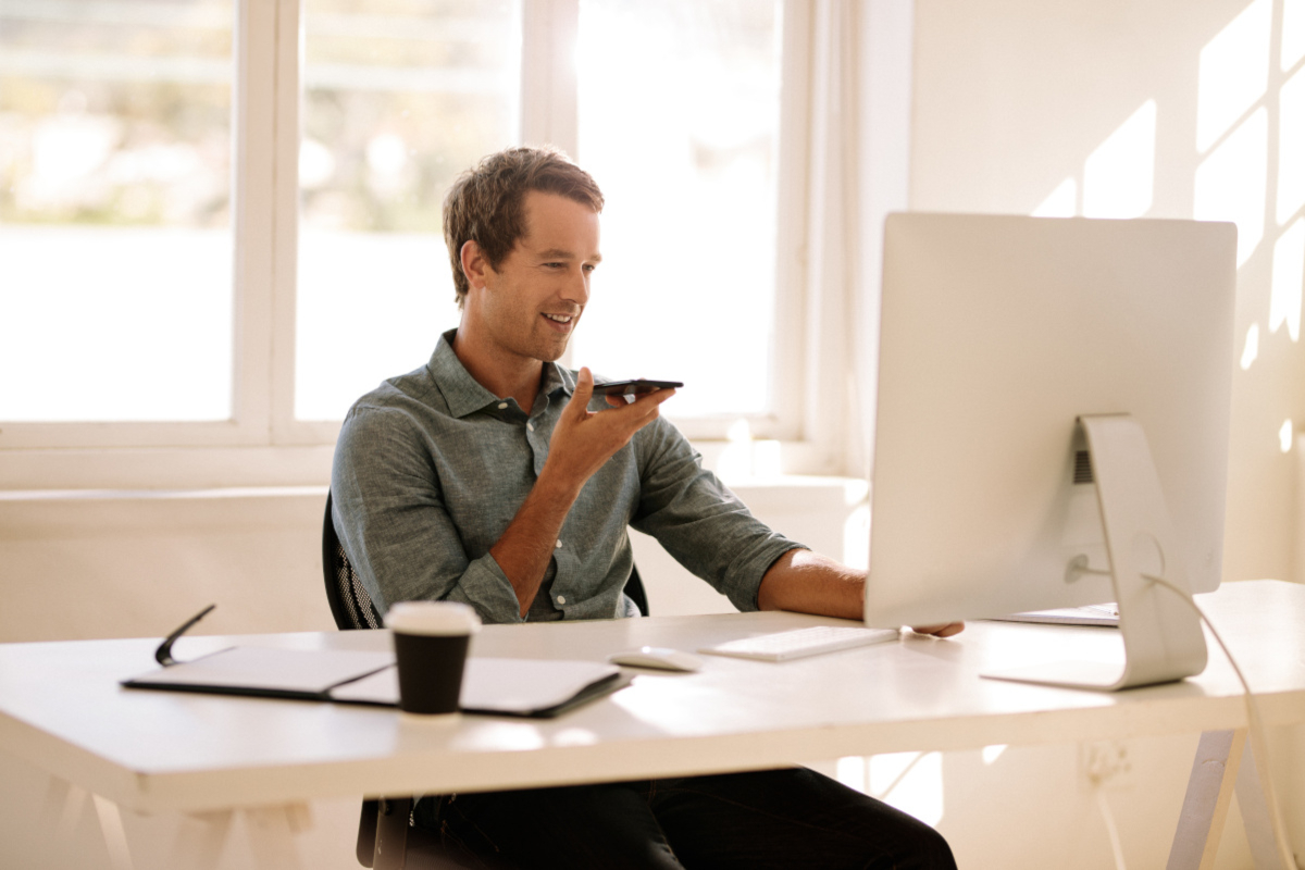 Man talking on phone and looking at computer