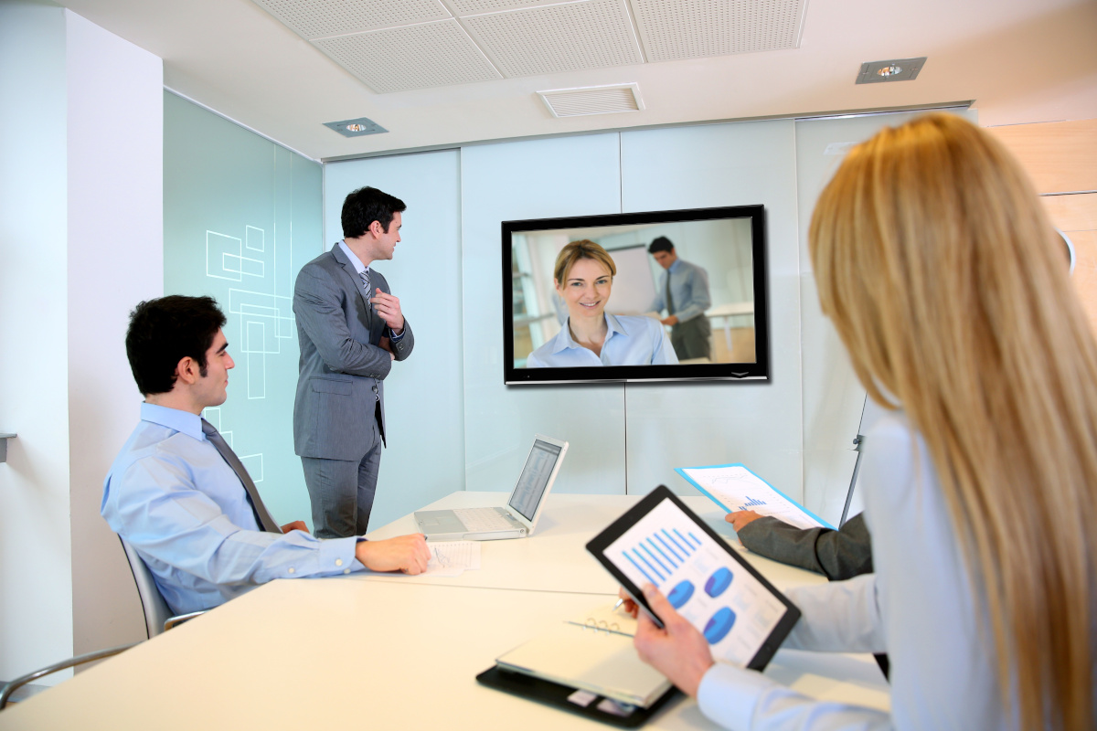 A team communicating with remote employees through a video conference
