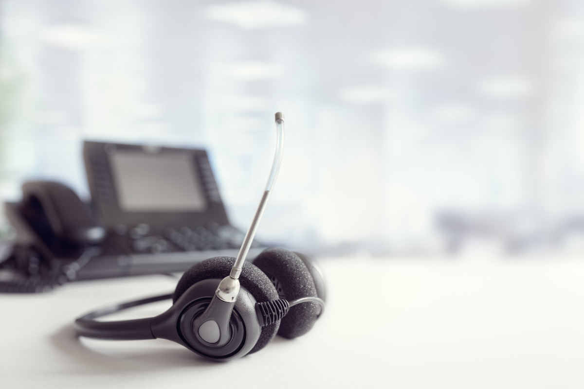 A business phone and a headset on a desk