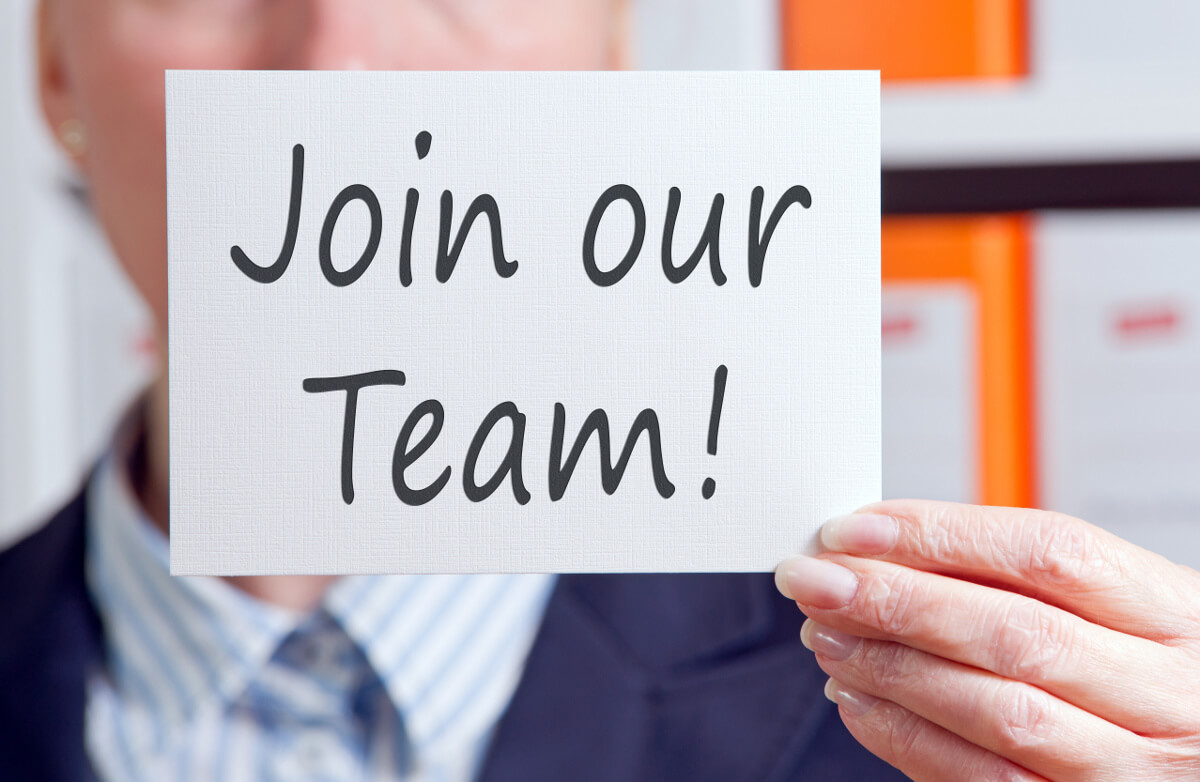 Close Up Businesswoman's Hand Holding 'Join Our Team' Sign