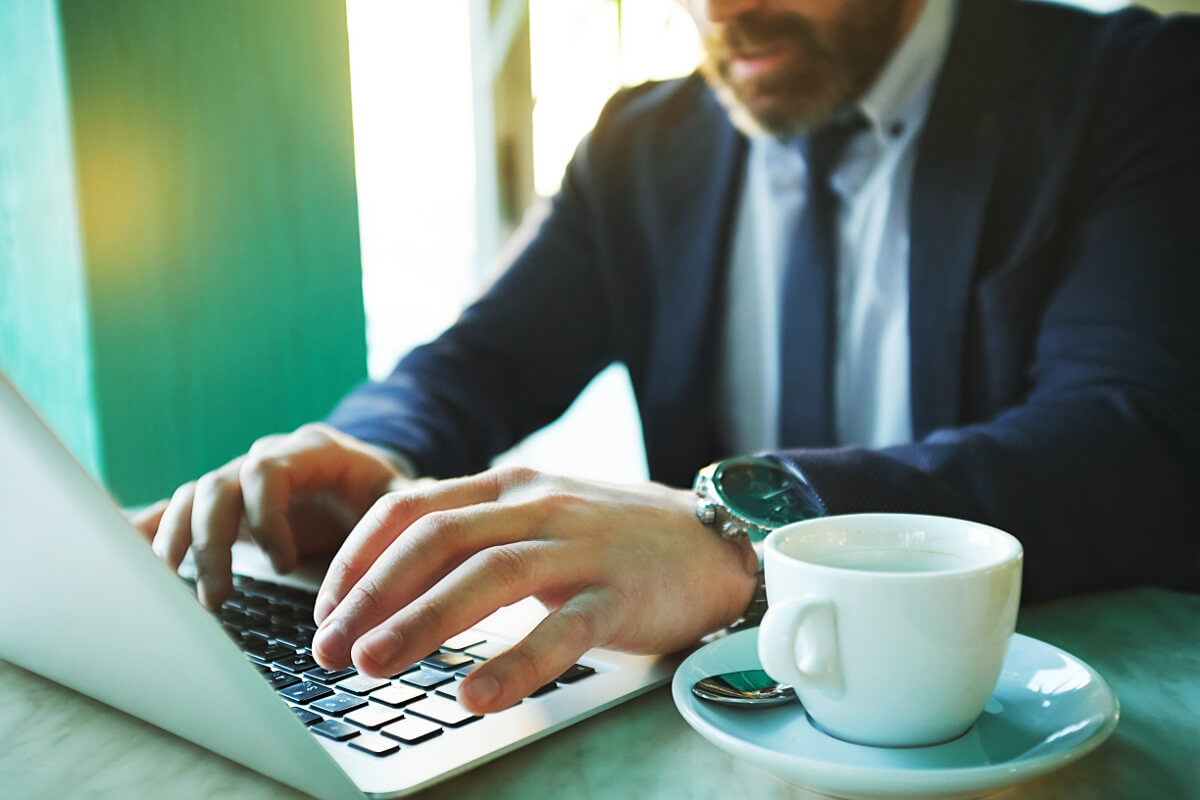 Businessman Working Remotely on Laptop in Coffee Shop VoIP Technology Concept